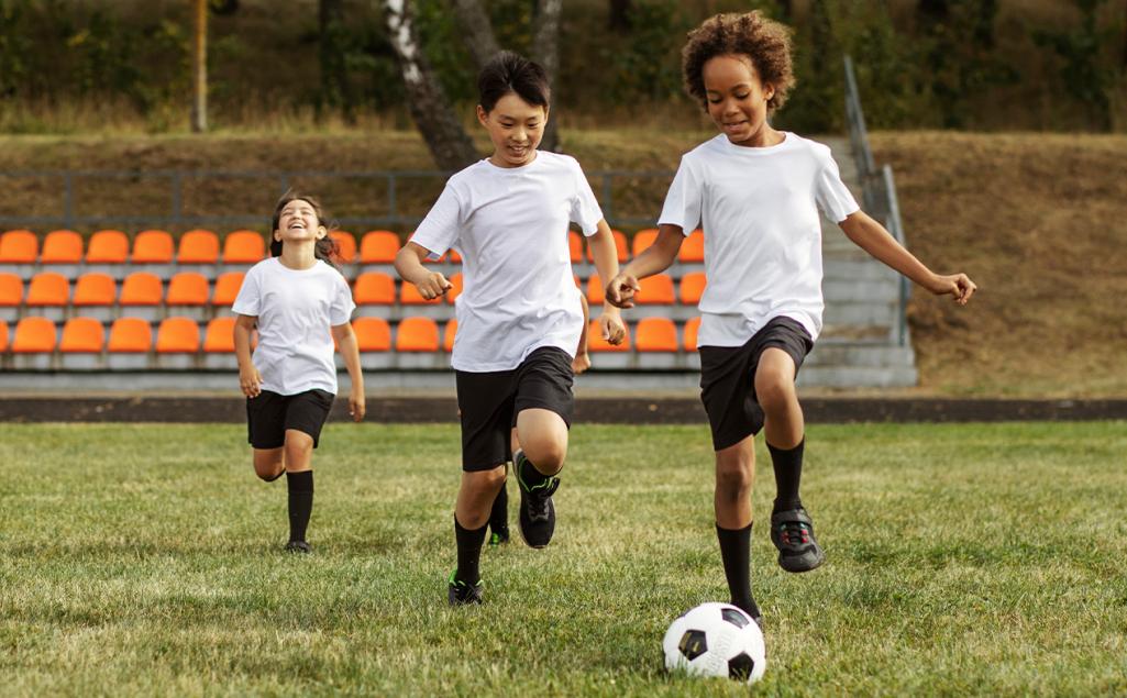 Three kids playing soccer.