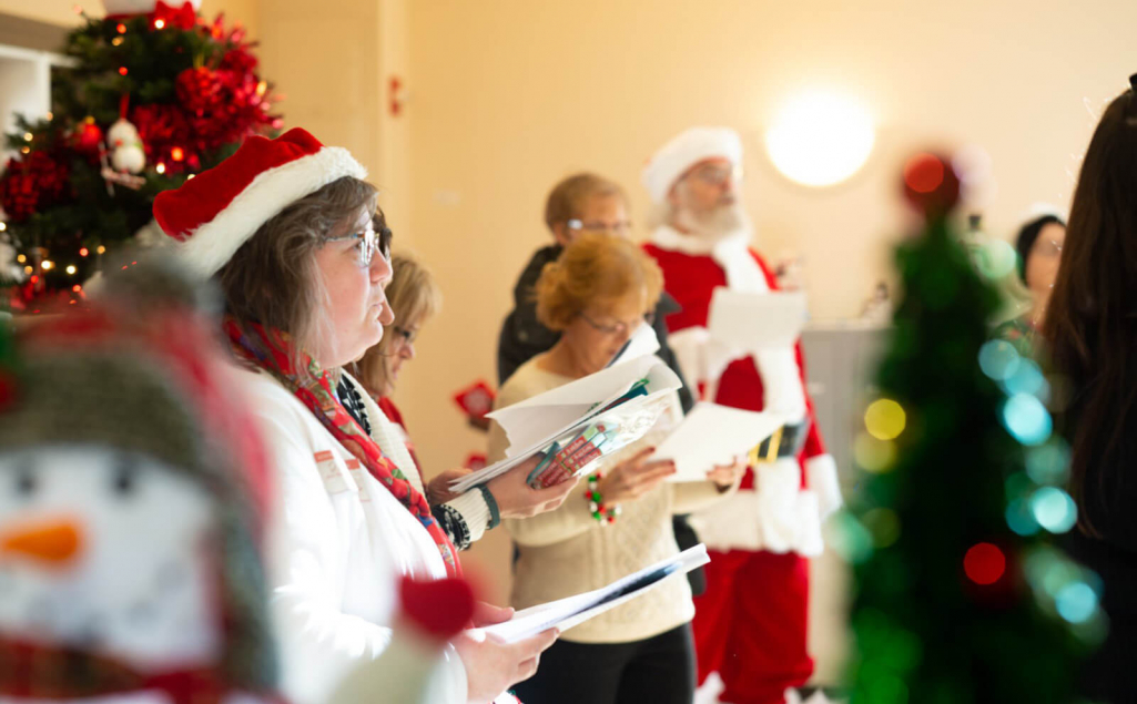 People singing Christmas carols at a long-term care facility.