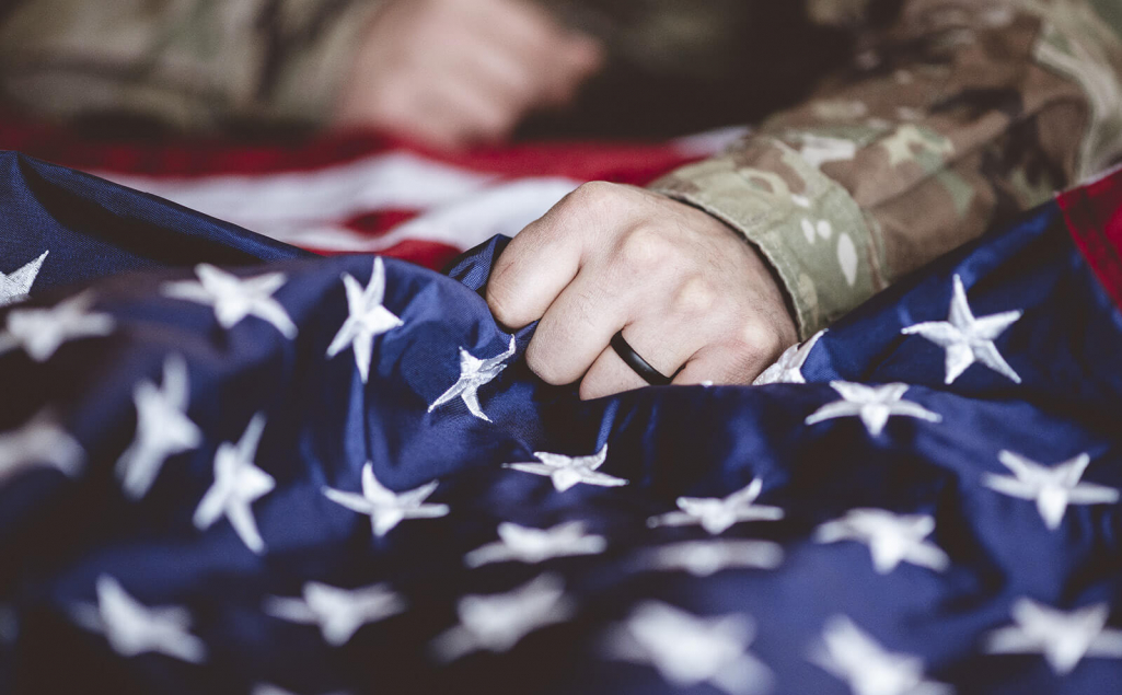 Military veteran holding an American flag.