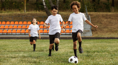 Three kids playing soccer.