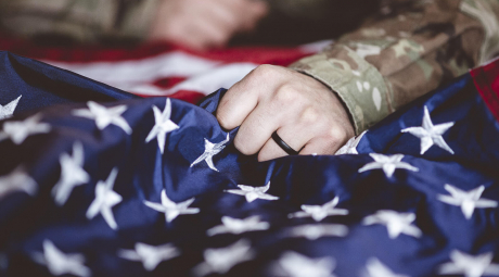 Military veteran holding an American flag.