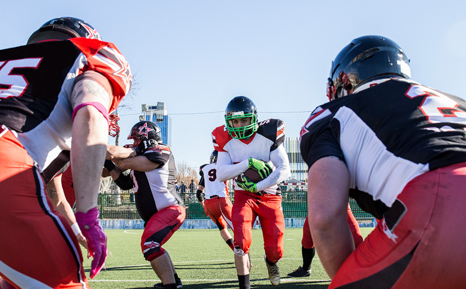 A running back carrying the football while facing a tackle.