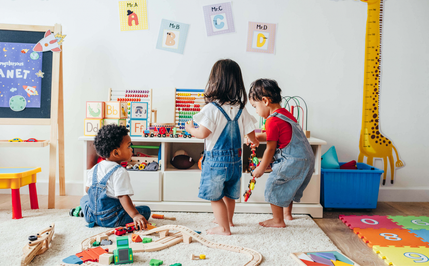 Three small children playing together at daycare.