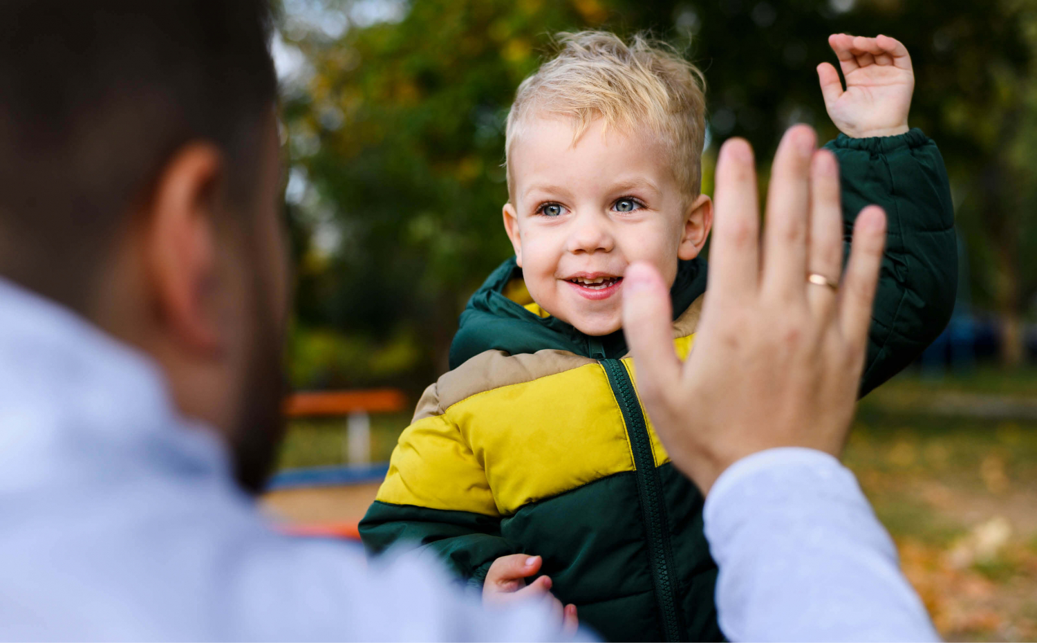 A dad high-fiving his toddler.